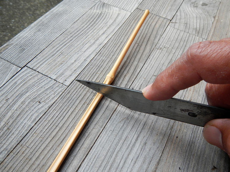 ノコギリで切ると竹が割れる心配があるので、小刀を使い慎重に切り落とします。
